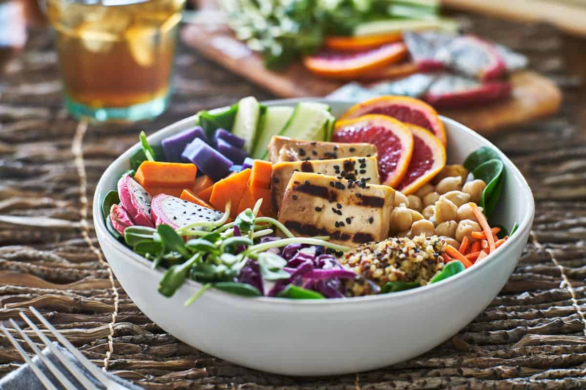 colorful buddha bowl with grilled tofu and pea shoots