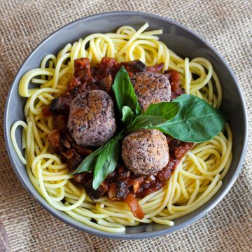 Vegan meatballs in a bowl with spaghetti.